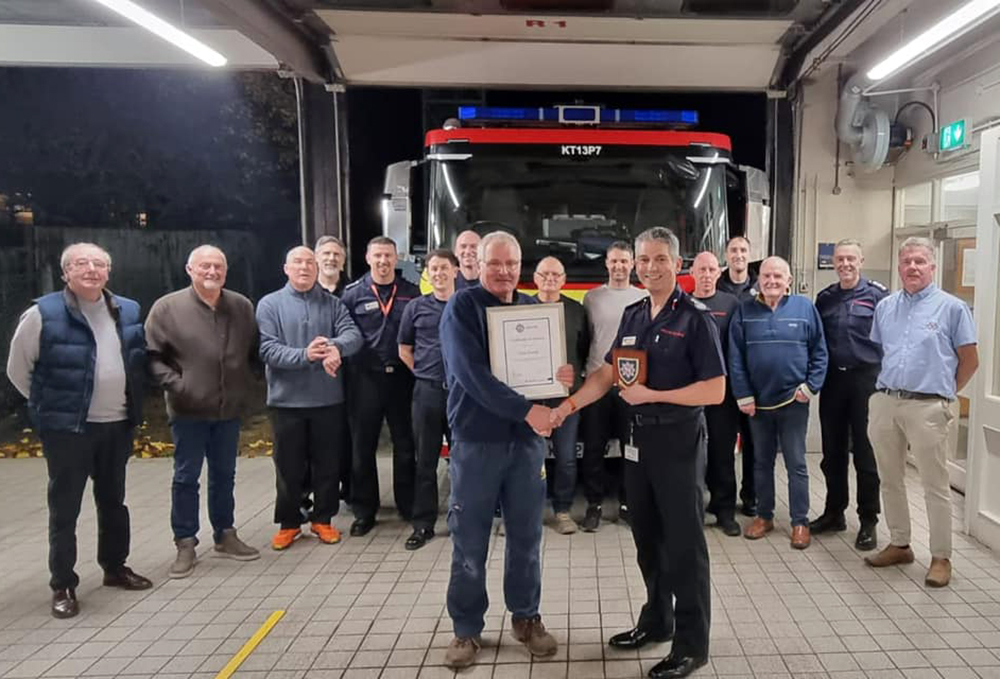 Chief fire officer Ben Ansell with Phil, surrounding by colleagues past and present. Picture: Blandford Fire Station