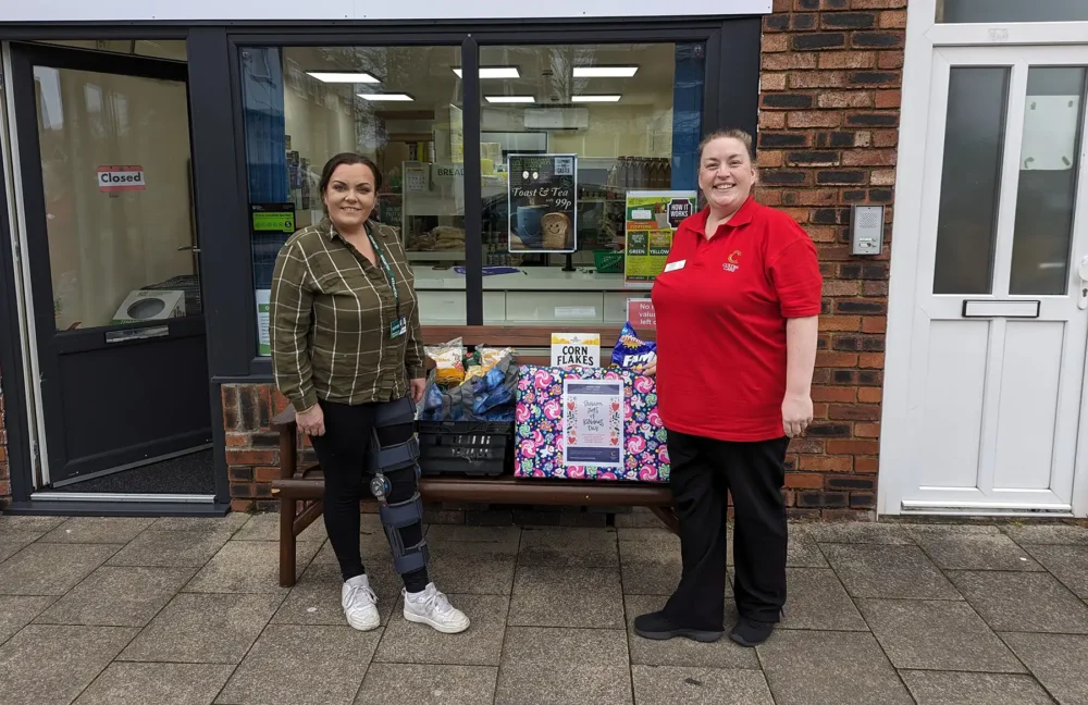 Lauren Parrett, right, Companionship Team Leader at Colten Care’s Brook View care home, hands over donated food items to Michelle Bennett who manages the nearby community larder in West Moors