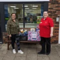 Lauren Parrett, right, Companionship Team Leader at Colten Care’s Brook View care home, hands over donated food items to Michelle Bennett who manages the nearby community larder in West Moors