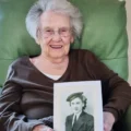 Elizabeth House resident Kathleen with a photo of herself aged 18 in her Wren uniform