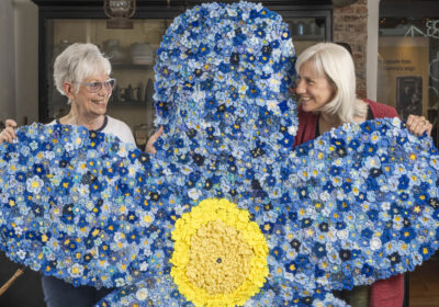 Museum of East Dorset staff, Heather Bird and Amanda Peroni with a giant forget-me-not flower which is made from thousands of tiny donated knitted flowers Picture: ZacharyCulpin/Bournemouth News and Picture Service
