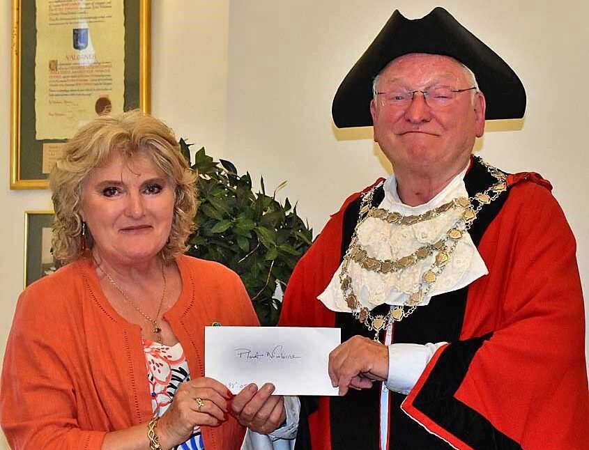 Heather Lowe from Planet Wimborne receiving the donation from cllr Jeff Hart Picture: Tom Scrase